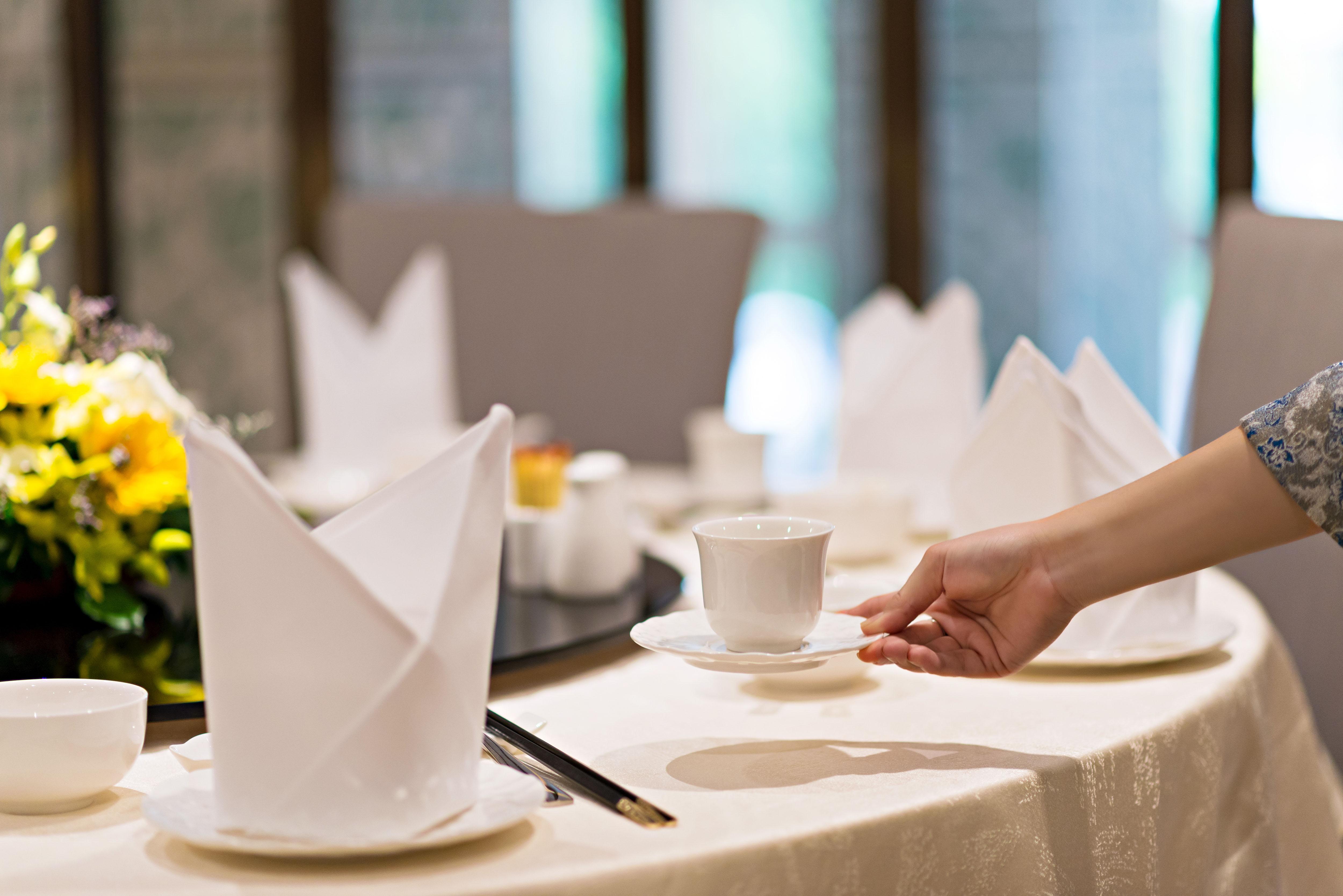 Eastin Grand Hotel Saigon Ho Chi Minh City Bagian luar foto A server sets a table at a restaurant.